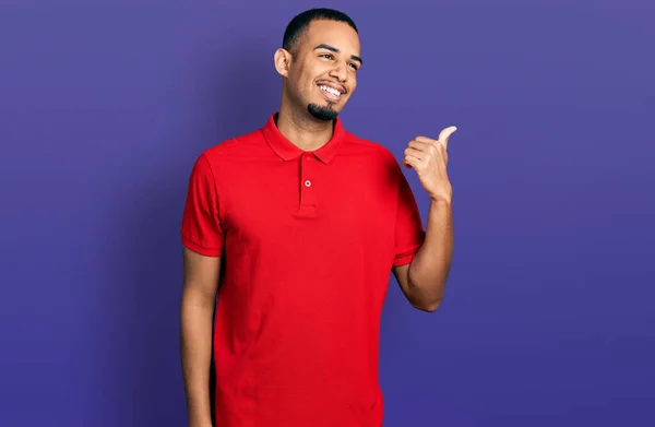 Joven Afroamericano Con Polo Casual Apuntando Con Pulgar Hacia Costado —  Fotos de Stock