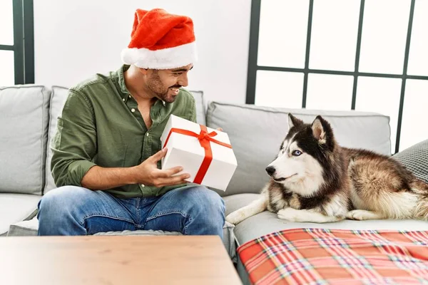 Genç Spanyol Bir Adam Elinde Hediyeyle Evde Köpekle Oturuyor — Stok fotoğraf