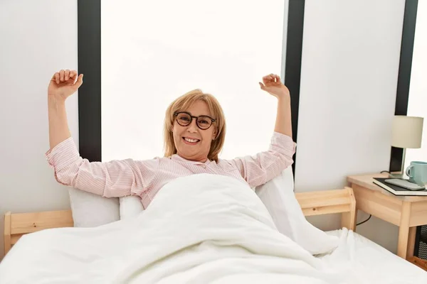 Middle Age Blonde Woman Stretching Arms Waking Bed Home — Stock Photo, Image