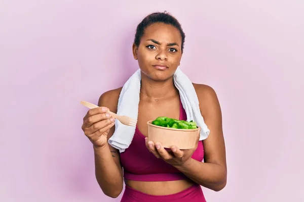 Chica Afroamericana Joven Que Usa Ropa Deportiva Comiendo Ensalada Expresión —  Fotos de Stock