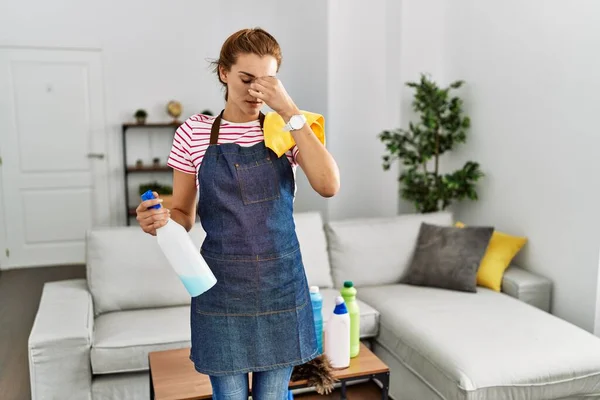 Jonge Brunette Vrouw Draagt Schort Met Schoonmaakmiddelen Thuis Moe Wrijven — Stockfoto