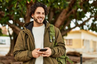 Şehirde akıllı telefon kullanan yakışıklı bir İspanyol.
