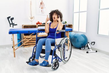 Fizyoterapi kliniğinde tekerlekli sandalyede oturan genç ortadoğulu kadın şaşırmış ve şaşırmıştı.. 