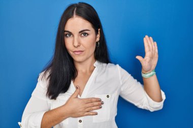 Mavi arka planda duran genç İspanyol kadın avuçlarında ve göğsünde yemin ederek sadakat yemini ediyor. 