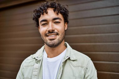 Yakışıklı, sakallı, güneşli bir günde mutlu bir şekilde gülümseyen bir İspanyol.