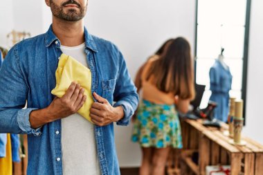 Genç İspanyol soyguncu elbise dükkanından gömlek çalıyor..