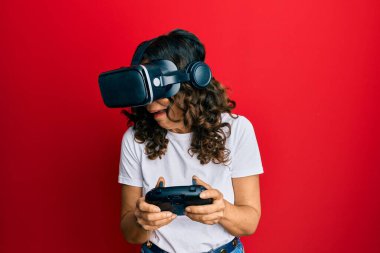 Sanal gerçeklik gözlüğü takan orta yaşlı bir kadın 3 boyutlu video oyunları oynuyor, gelecekteki simülasyonları izliyor, heyecan verici deneyimler yaşıyor.