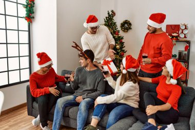 Bir grup genç Noel hediyesini evde şarap içerek kutluyor..