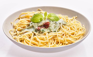  Beyaz yalıtılmış arka planda pesto soslu İtalyan spagettisi.