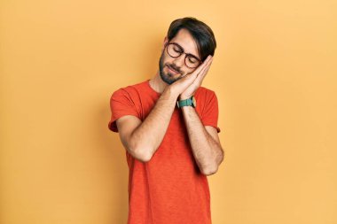 Gündelik kıyafetler ve gözlük takan genç İspanyol adam uyuyordu. Yorgun düşler görüyordu ve elleriyle poz veriyordu. Gözleri kapalı gülümsüyordu.. 
