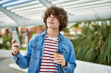 Genç İspanyol adam şehirde akıllı telefon kullanıyor.