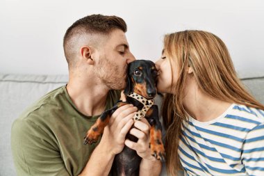 Evdeki kanepede oturan İspanyol bir çift öpüşüyor..