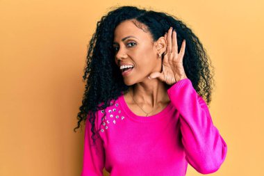 Orta yaşlı Afro-Amerikalı kadın, günlük kıyafetler giyip, sırıtarak dedikodu ve dedikoduları dinliyor. Sağırlık kavramı. 