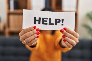 Genç Latin kadın hasta klinikte yardım pankartı taşıdığını vurguladı