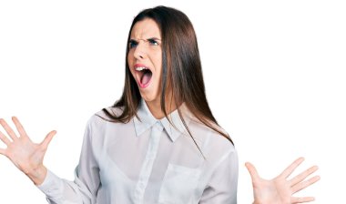 Genç esmer kız beyaz iş gömleği giyiyor deli gibi bağırıyor, agresif bir ifadeyle bağırıyor ve kollarını kaldırıyor. hüsran kavramı. 