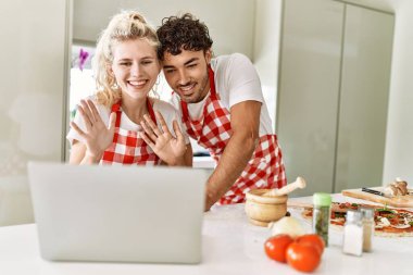 Mutfakta dizüstü bilgisayar kullanan mutlu bir çift..