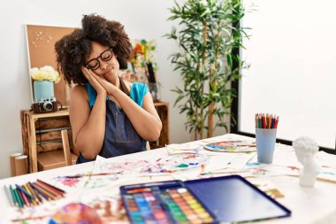 Güzel afro saçlı Amerikalı kadın sanat stüdyosunda resim yapıyor. Yorgun uyuyor, hayal kuruyor, elleriyle poz veriyor ve gözleri kapalı gülümsüyor.. 