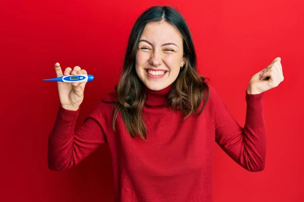 Jovem Morena Segurando Termômetro Gritando Orgulhoso Celebrando Vitória Sucesso Muito — Fotografia de Stock