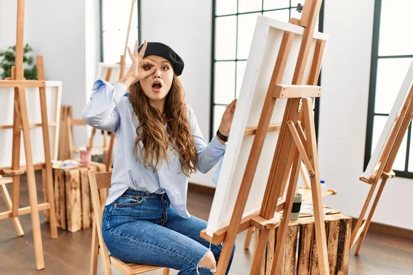 Young Hispanic Artist Woman Painting Canvas Art Studio Doing Gesture — Stock Photo, Image