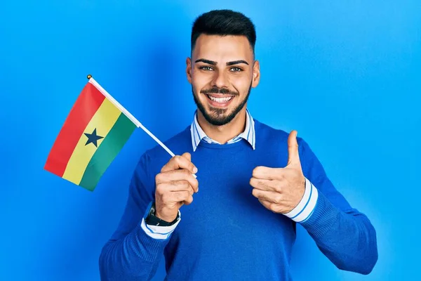 Joven Hombre Hispano Con Barba Sosteniendo Bandera Ghana Sonriendo Feliz —  Fotos de Stock