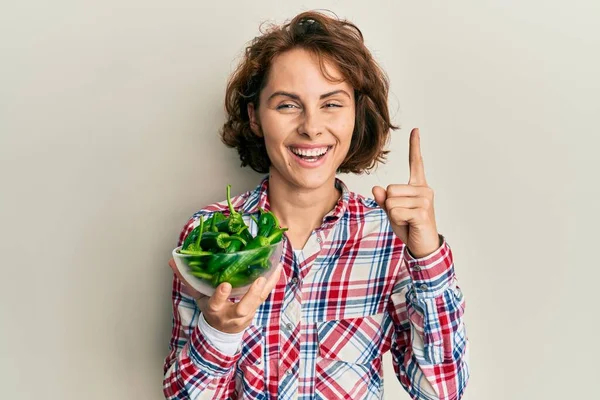 Joven Morena Sosteniendo Tazón Con Pimientos Verdes Sonriendo Con Una —  Fotos de Stock