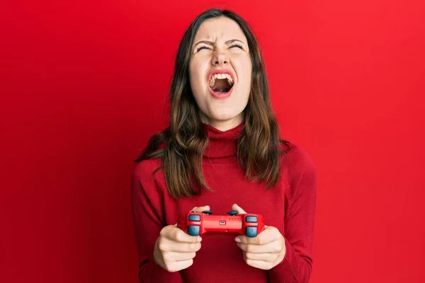 Young Brunette Woman Playing Video Game Holding Controller Angry Mad — Stockfoto