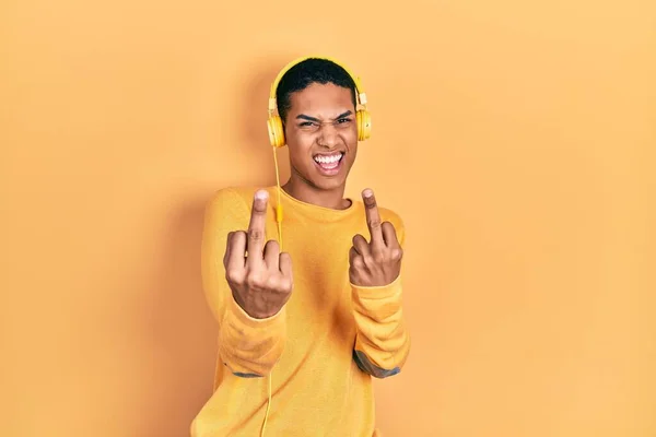 Young African American Guy Listening Music Using Headphones Showing Middle — Fotografia de Stock