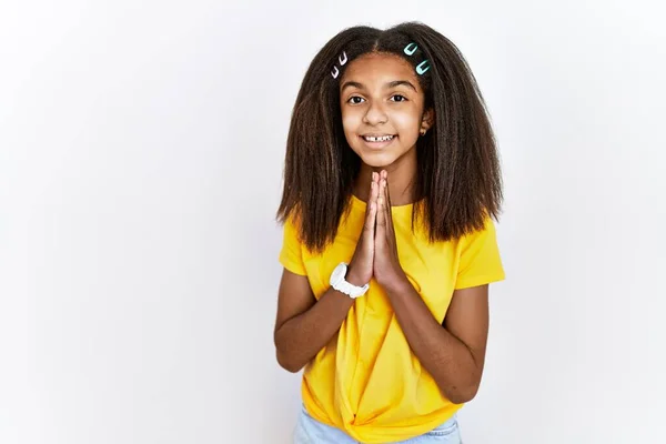 若いアフリカ系アメリカ人の女の子は白い孤立した背景に立って一緒に手で祈っている自信を笑顔許しを求めて — ストック写真