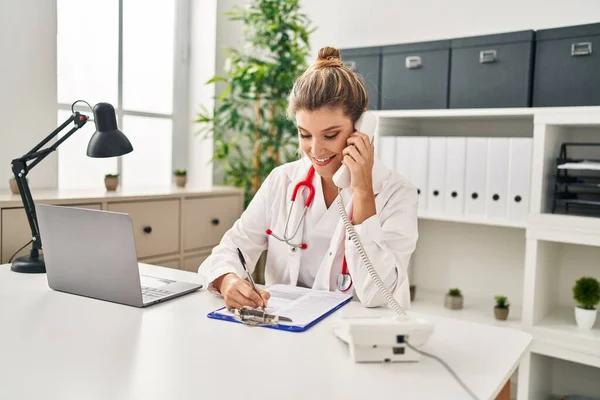 Jovem Loira Vestindo Uniforme Médico Falando Telefone Clínica — Fotografia de Stock