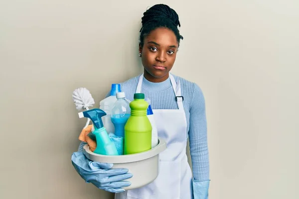 Mujer Afroamericana Con Cabello Trenzado Usando Delantal Sosteniendo Productos Limpieza —  Fotos de Stock
