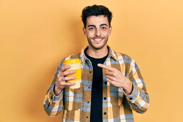 Joven Hispano Sosteniendo Café Sonriendo Feliz Señalando Con Mano Dedo —  Fotos de Stock