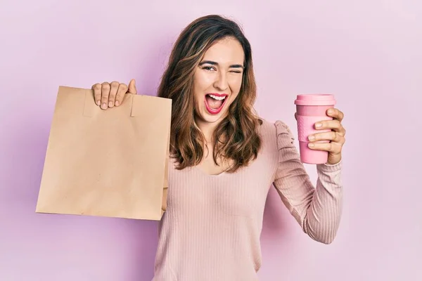 Young Hispanic Girl Holding Take Away Paper Bag Coffee Winking — Fotografia de Stock