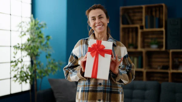 Mujer Hispana Mediana Edad Sonriendo Confiada Sosteniendo Regalo Casa — Foto de Stock