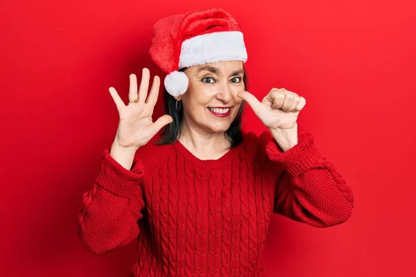 Middelbare Leeftijd Spaanse Vrouw Met Kerstmuts Tonen Wijzen Met Vingers — Stockfoto