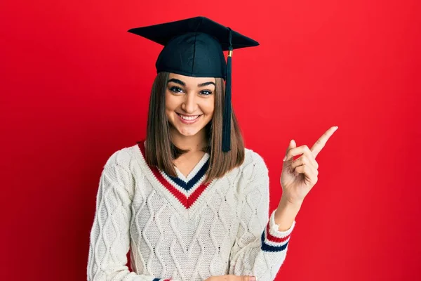 Young Brunette Girl Wearing Graduation Cap Smiling Happy Pointing Hand — ストック写真