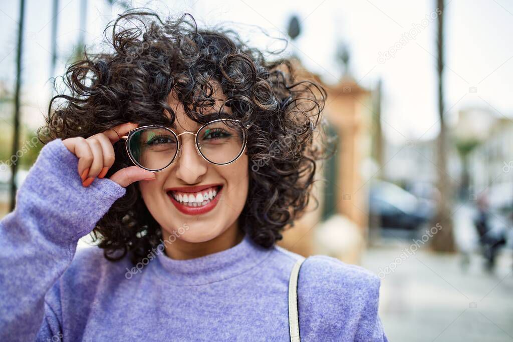 Young middle east woman smiling confident wearing glasses at street