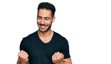 Siyah tişörtlü İspanyol sakallı adam başarı için heyecanlanıyor kolları havada ve gözleri kapalı zaferi kutluyor. Kazanan konsept. 