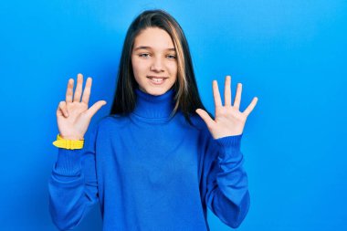 Balıkçı yaka kazak giyen genç esmer kız dokuz numarayı gösterip işaret ederken kendine güvenen ve mutlu bir şekilde gülümsüyor.. 