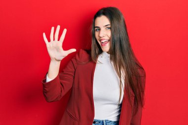 Genç esmer genç, iş ceketi giyiyor ve beş numarayı göstererek gülümsüyor. Kendinden emin ve mutlu.. 