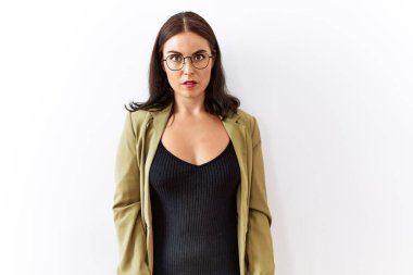 Soyutlanmış arka planda duran esmer kadın yüzünde ciddi bir ifadeyle rahatlamış. Basit ve doğal bir şekilde kameraya bakıyorsun.. 