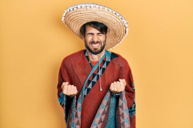 Meksika şapkası tutan genç İspanyol adam kolları havada ve gözleri kapalı zaferi kutlarken heyecanla bekliyor. Kazanan konsept. 