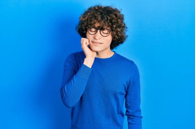 Yakışıklı genç adam günlük kıyafetler giyiyor ve diş ağrısı ya da diş hastalığından dolayı ağızlarına acı dolu bir ifadeyle dokunuyor. dişçi 