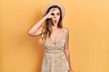 Yaz şapkası takan genç İspanyol kız şaşırmış yüz ifadesiyle şok olmuş, parmaklarından bakan gözler. İnançsız ifade. 