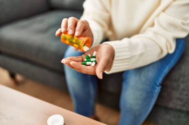 Orta yaşlı İspanyol kadın evde hap alıyor.