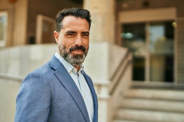 Orta yaşlı işadamı şehirde mutlu mesut dikilirken.