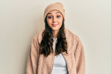 Genç İspanyol kadın yün kazak giyiyor ve şapkalı komik yüzlü yanak şişiriyor. Havayla şişmiş ağız, çılgın bir ifade.. 