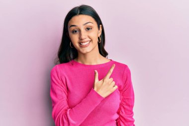 Yüzünde mutlu ve doğal bir ifade olan, elleri ve parmaklarıyla işaret eden, güler yüzlü, gündelik kıyafetler giyen genç İspanyol kadın. 