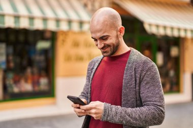 Sokakta akıllı telefon kullanan kendine güvenen genç adam.