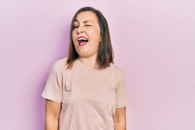 Orta yaşlı İspanyol kadın gündelik giysiler içinde kameraya seksi bir ifadeyle bakıyor, neşeli ve mutlu bir yüzle.. 