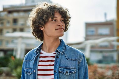 Genç İspanyol adam şehre gülümsüyor.